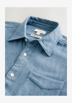 Hellblaues Hemd mit Knopfleiste, spitzem Kragen, Brusttasche und weißen Knöpfen, aus weichem, strukturiertem Stoff.