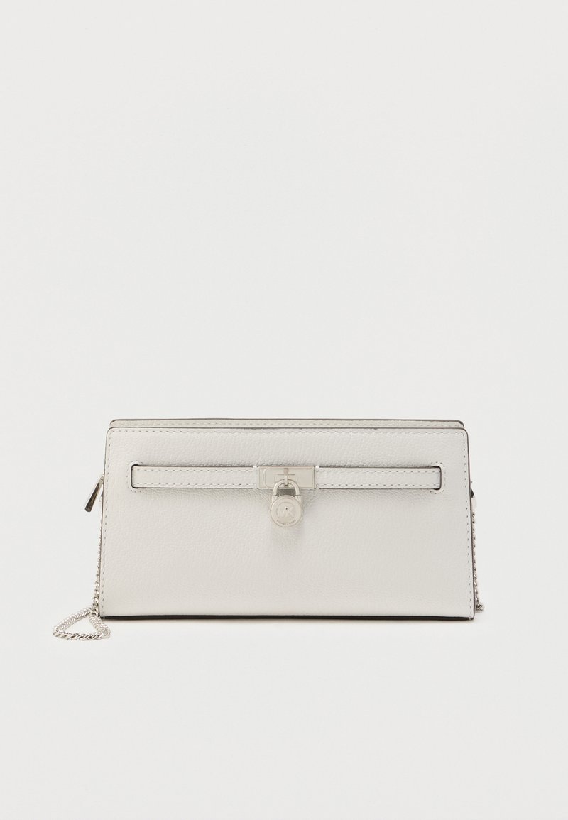 Bela usnjena denarnica z gladko teksturo, okrašena s srebrnim zaklepnim detajlom, odstranljivim verižnim trakom in vodoravnim žepom z zadrgo.