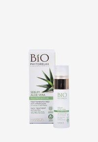 Aloe Vera ansiktsbehandlingsflaska, vit med metallisk guldaccent, bredvid en grön och vit kartong med växtgrafik och text.