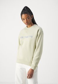 Lys grønn hettegenser med rund hals og ribbestrikkede ermer. Har "carhartt." brodert i lyseblått over brystet.