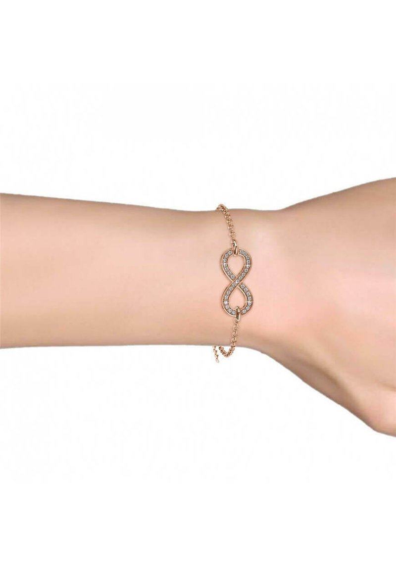 Bracciale in oro rosa con simbolo dell'infinito abbellito da gemme trasparenti, fissato da una delicata catena con chiusura regolabile.