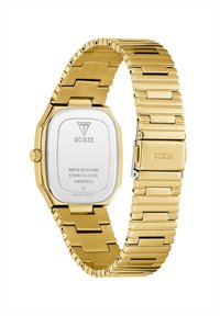Montre en acier inoxydable doré avec un cadran octagonal, bracelet en métal, étanche, arborant le logo de la marque sur le cadran et le fermoir. Bracelet à maillons ajustable.