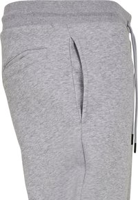 Grijze sweatpants van een zachte katoenmix. Voorzien van een geribde tailleband, zijzak en trekkoord voor een verstelbare pasvorm. Gladde textuur.