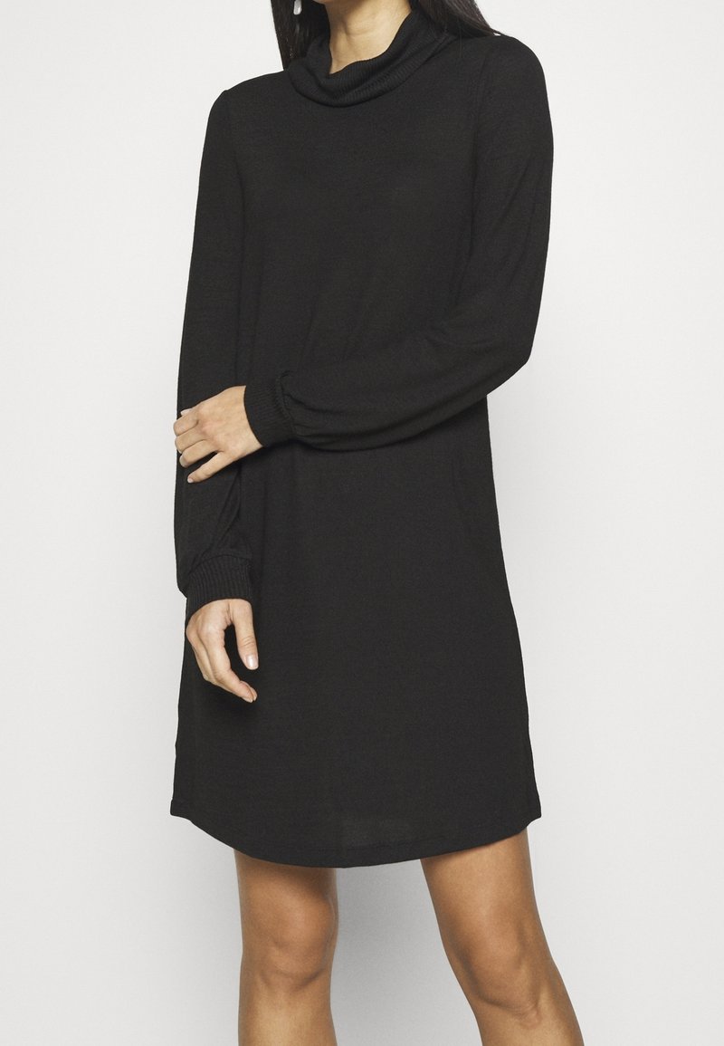 Schwarzes Kleid aus weichem Stoff, mit einem Wasserfallausschnitt, langen Ärmeln und einer lockeren Passform, das bis zur Mitte des Oberschenkels reicht. Einfaches Design, ohne Muster.