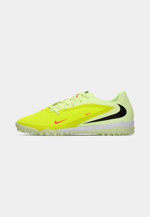 Jasne žlté futbalové topánky Nike s čiernymi a červenými logami swoosh, textúrovaný zvršok a trávnatá podrážka, zobrazené v bočnom pohľade orientovanom doľava.