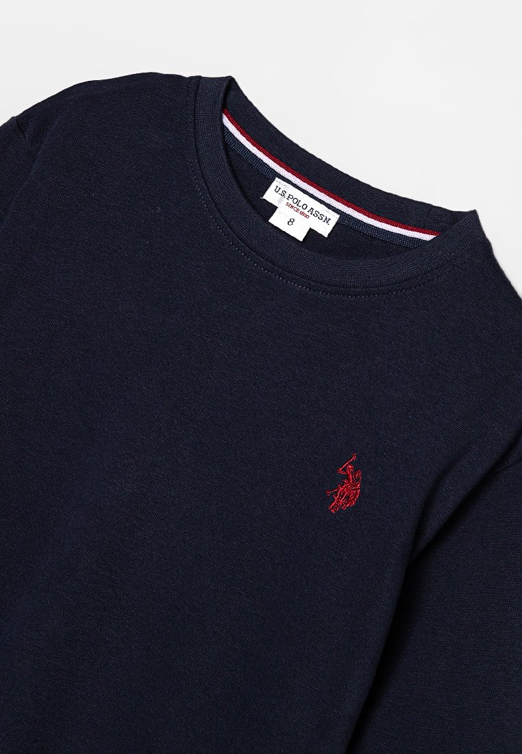 Marineblauer Baumwollpullover mit rundem Halsausschnitt, ausgestattet mit einem kleinen roten gestickten Logo auf der Brust und einem kontrastierenden gestreiften Kragen.