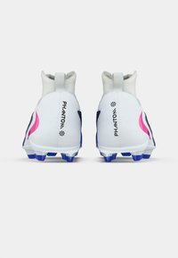 Λευκά και μαύρα ποδοσφαιρικά παπούτσια με ροζ λεπτομέρεια, σχεδίαση υψηλού αστραγάλου, υφή στην επιφάνεια και μπλε καρφιά στην σόλα. Ορατή η επιγραφή "PHANTOM".