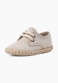 Scarpa in tela di cotone beige con punte rotonde, due occhielli metallici e cuciture in corda testurizzata lungo la suola. Lacci di colore naturale.