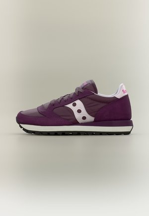 Μωβ και λευκό αθλητικό παπούτσι Saucony με κορδόνια, μαύρη σόλα με σχέδιο και ροζ λογότυπο στη φτέρνα και τη γλώσσα, εμφανίζεται σε προφίλ πλάγια με απλό φόντο.