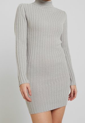 Hellgraues geripptes Strickkleid mit langen Ärmeln und Rollkragen, figurbetonte Silhouette, die über den Knien an einer stehenden Person endet.