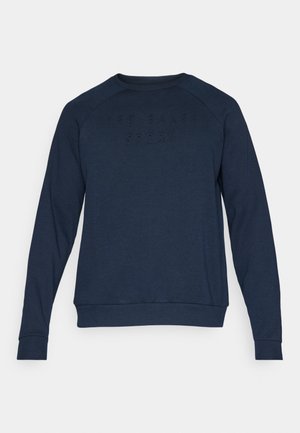 Felpa blu navy con colletto rotondo, maniche raglan e lettering in rilievo "TED BAKER SPORT" sul petto. Texture morbida, tessuto elasticizzato.