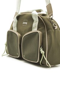 Olivgrüne Tasche mit zwei Netztaschen an der Vorderseite, cremefarbenen Akzenten, verstellbarem Tragegurt und Reißverschluss. Hergestellt aus strapazierfähigem Stoff mit glatter Textur.