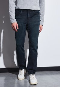 Tmavě modré džíny se střihem rovného nohavice. Vyrobeny z denimu, s klasickým pětiúhelníkovým designem a jemnými švy.