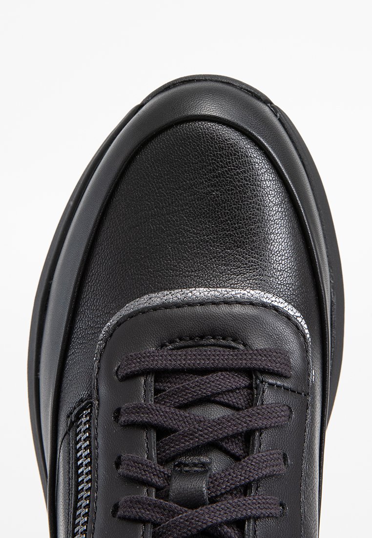 Schwarze Leder-Sneaker mit strukturiertem Obermaterial, runder Zehenpartie, dunklen Schnürsenkeln und silbernen Akzenten entlang der Kante. Mit seitlichem Reißverschluss für einfaches An- und Ausziehen.