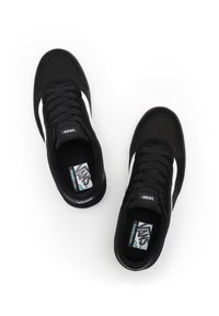 Black canvas sneakers with white side stripe, flat laces, padded collar, and cushioned insole. Features logo on tongue and insoles.