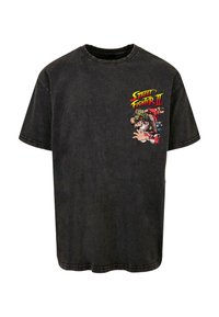 Sort bomulds t-shirt med et fronttryk af "Street Fighter II" karakterer i livlige farver. Korte ærmer og rund halsudskæring.