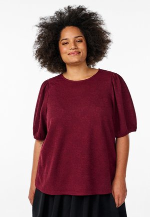 Burgundy short-sleeve top featuring a textured floral pattern and a round neckline. Fits loosely with puffed sleeves, accentuating comfort.
