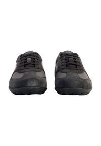 Scarpe sportive nere realizzate in materiali scamosciati e in rete, con design a punta arrotondata, suole in gomma flat e un sistema di allacciatura prominente.