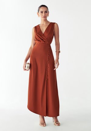 Lang, rustfarvet kjole med V-hals, omslagsstil og knapdetaljer i siden. Glat tekstur og flydende silhuet, der strækker sig til anklerne.