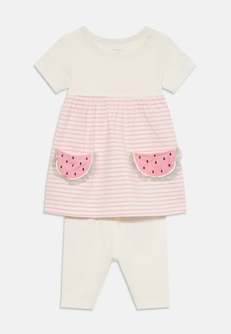 T-shirt à manches courtes, blanc avec des rayures roses, présentant des appliqués de poches en forme de pastèque ; accompagné de leggings blancs unis. En tissu coton doux.