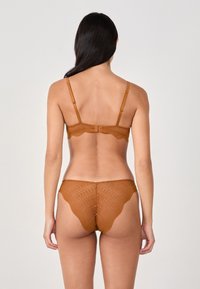 Brown lace bra and thong set featuring scalloped edges and a patterned texture; adjustable straps and a hook closure at the back.