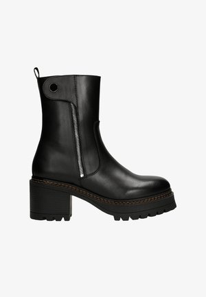 Black leather ankle boot with a chunky heel, side zip closure, and decorative stitching along the sole. Features a pull tab on the back.
