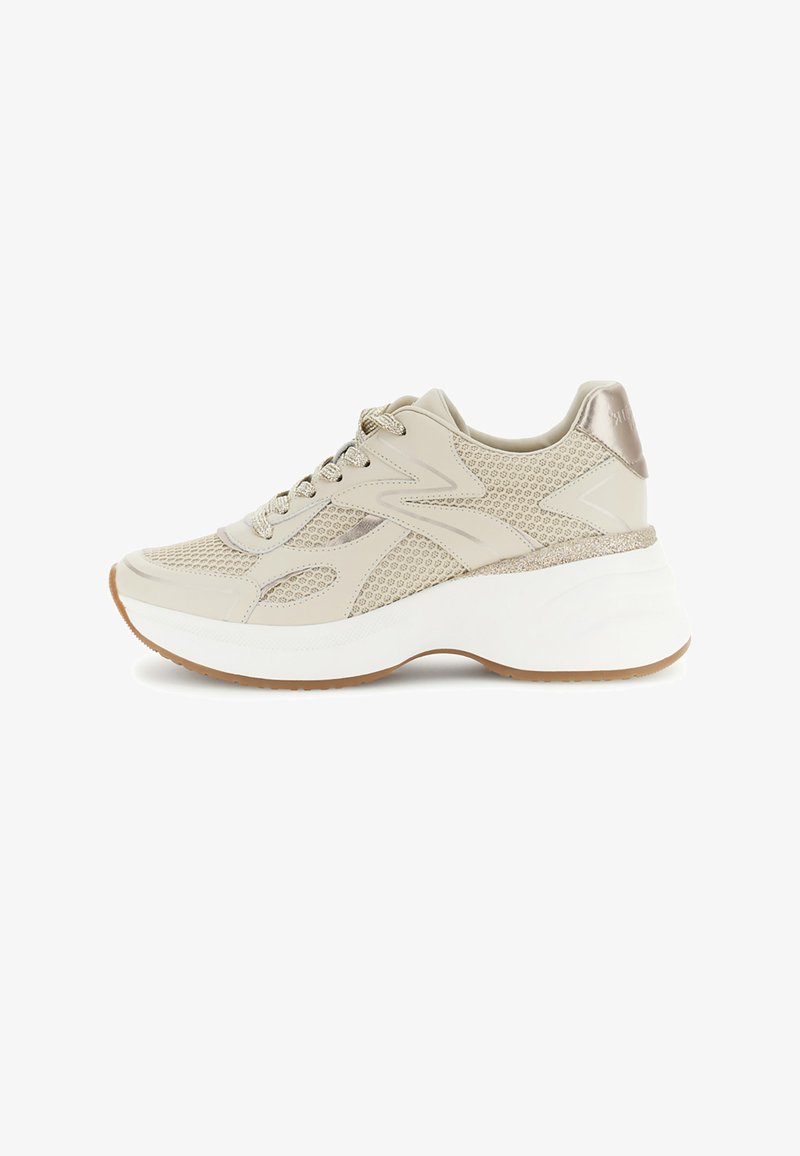 Beige snørestøvle med mesh- og læderpaneler, tyk hvid sål og metallisk detalje på hælen, vist i profil vendt mod venstre.