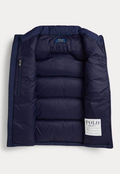 Interno di giacca imbottita blu navy con tasca con cerniera sul lato sinistro, etichette Polo Ralph Lauren sul collo e sulla fodera inferiore destra.