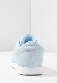 Basket bleu clair en daim Reebok avec une semelle blanche sur une surface et un fond blancs, légèrement inclinée vers la droite.