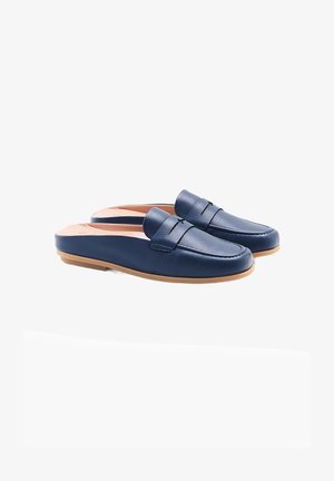 Des chaussures slip-on en cuir bleu marine avec une texture lisse, présentant un design cousu et une semelle en caoutchouc brun. Pas de matériel ou de motifs visibles.