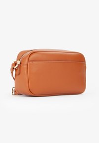 Borsa a tracolla in pelle arancione con chiusura a zip, forma rettangolare, superficie liscia e una tasca esterna discreta. Finiture in metallo dorato.