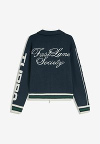 Pull en maille bleu marine avec le texte blanc "Fast Lane Society" brodé au dos, des poignets et un ourlet à rayures blanches et vertes, et un texte audacieux en blanc sur les manches.