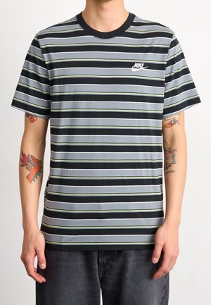 Gestreept T-shirt met korte mouwen in grijs, zwart en dunne groene strepen; heeft een ronde zwarte halslijn en een wit Nike-logo op de borst.