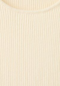 Tissu en maille côtelée crème avec des lignes verticales et un col rond, montrant la texture et la douceur du matériau.