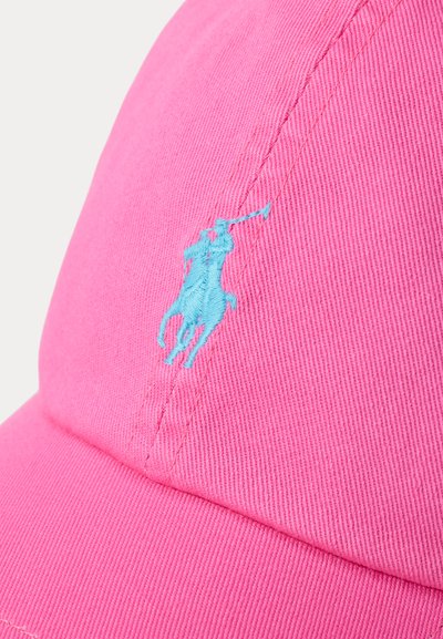 Ροζ καπέλο μπέιζμπολ με λογότυπο σε ανοιχτό γαλάζιο κεντημένο που απεικονίζει παίκτη πόλο πάνω σε άλογο, που κρατά υψωμένο το ρόπαλο.