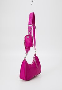 Borsa a tracolla sintetica rosa con forma strutturata, dotata di un compartimento principale con zip e una mini borsa removibile sulla tracolla.