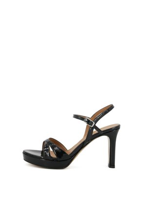 Sandalo con tacco alto in vernice nera, con plateau, cinturini incrociati sulle dita dei piedi e cinturino regolabile con fibbia alla caviglia.