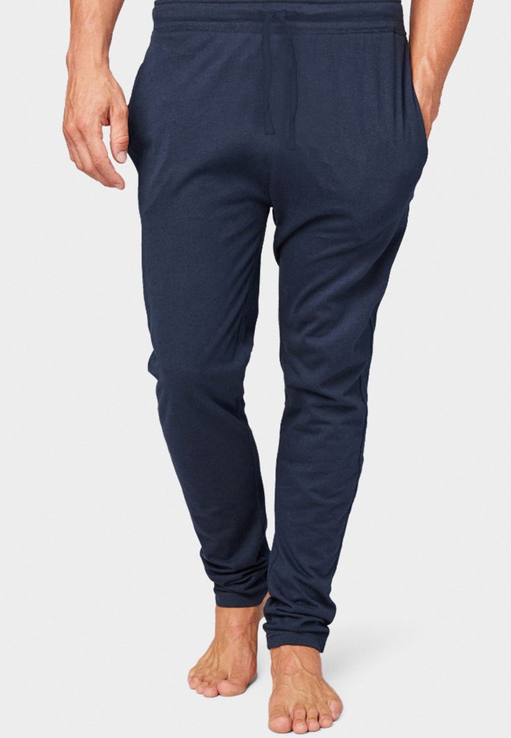 Pantalons de survêtement cintrés bleu marine en tissu doux avec une taille élastique, un cordon de serrage et des poches latérales. Texture lisse et poignets ajustés.