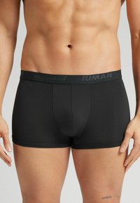 Schwarze Boxershorts mit engem Schnitt, aus glattem Material. Verfügt über einen breiten, elastischen Bund mit aufgedrucktem Markennamen.