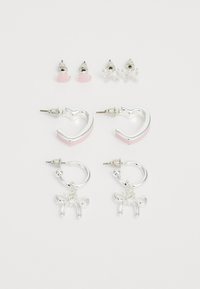 Ensemble de quatre boucles d'oreilles : deux créoles en argent avec des accents roses, deux clous d'oreilles en forme de cœur et de nœud, tous présentant des finitions métalliques brillantes.