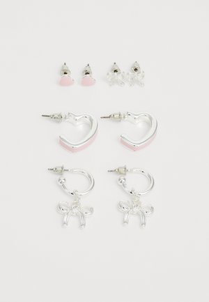 Súprava štyroch náušníc: dve strieborné kruhové náušnice s ružovými akcentmi, dve náušnice na naštipovanie v tvare srdca a mašle, všetky s lesklým kovovým povrchom.
