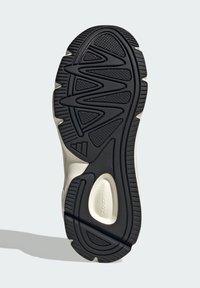 Čierna gumená podrážka s textúrovaným vzorom proti sklzu, obsahujúca vlnový dizajn a vystužené oblasti. Svetlý medzipodrážka zvyšuje trvácnosť.