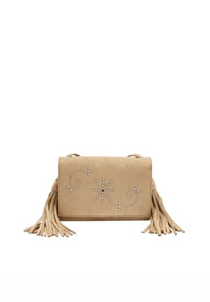 Beżowa zamszowa torba na ramię z ozdobnymi srebrnymi ćwiekami ułożonymi w kwiatowe wzory oraz długimi chwostami z frędzli po obu stronach.