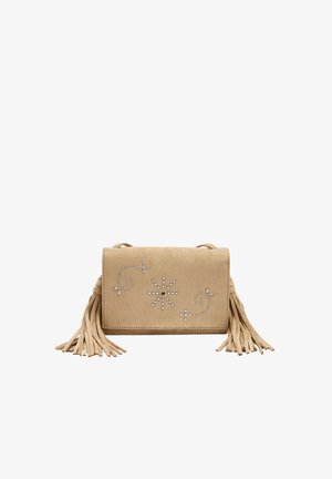 Beżowa zamszowa torba na ramię z ozdobnymi srebrnymi ćwiekami ułożonymi w kwiatowe wzory oraz długimi chwostami z frędzli po obu stronach.