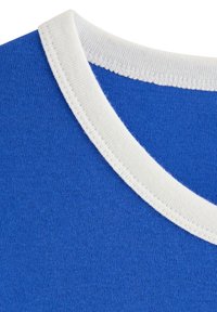 Blå bomuldst-shirt med krave, der har en hvid ribkant og fine syninger, med en glat tekstur og sømløst design.