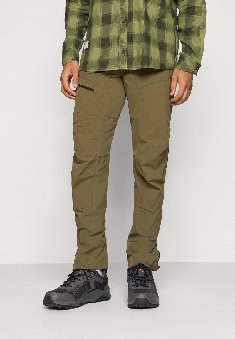 Pantalons d'extérieur khaki à coupe slim, fabriqués en tissu léger. Dotés de poches zippées et d'une construction durable. À associer avec des chaussures de randonnée noires.
