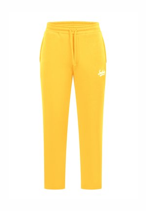 Pantalons de survêtement jaunes en tissu doux, avec une taille élastique à cordon de serrage et un petit logo blanc sur la cuisse gauche.