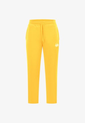 Pantalons de survêtement jaunes en tissu doux, avec une taille élastique à cordon de serrage et un petit logo blanc sur la cuisse gauche.