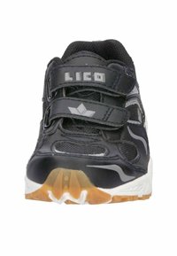 Schwarzer Sportschuh mit Mesh-Einsätzen, reflektierenden Akzenten, zwei Klettverschlüssen und einer strukturierten Gummisohle. Mit Logo auf der Zunge.