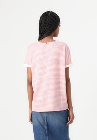 Pink and white striped t-shirt with a rounded neckline and short sleeves, made from soft fabric, worn with a denim skirt.